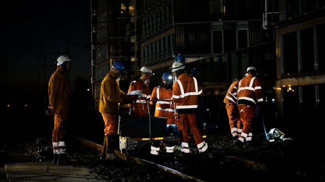 Cette photographie illustre particulièrement bien la dimension collective du chantier. Plusieurs personnes équipées de vêtements à haute visibilité, de casques et de lampes frontales interviennent autour du matériel installé sur la voie. Elle peut accompagner le passage consacré à la sécurisation, à l’organisation et à la coordination des opérations.